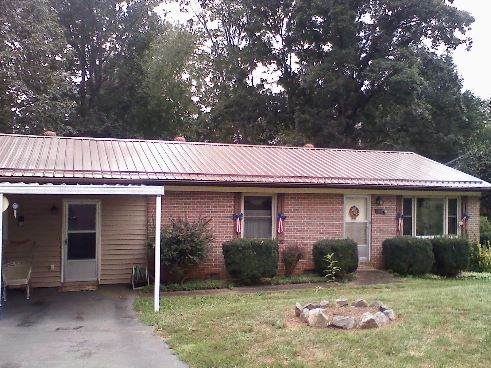 Bronze metal roof and carport on a brick ranch home — Roof Repair work by our crew in Wadena
